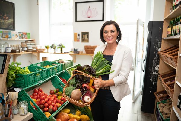 Bundesministerin Köstinger mit einem Korb frischen Obst und Gemüses im Unverpackt-Laden