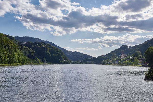 In der Mitte die Donau, rundherum ragen bewaldete Hügel auf, rechts ist eine kleine Ortschaft zu sehen