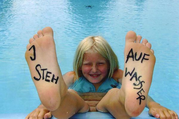 Mädchen im Wasser mit Fussaufschrift "I steh auf Wasser"