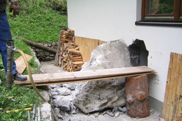 Damage from falling rocks on a house wall