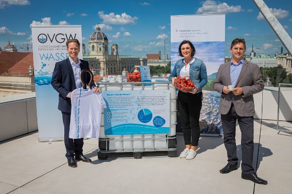Bundesministerin und zwei Herren in Anzug zeigen Produkte fuer die Wasser gebraucht wird