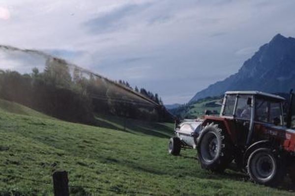 Traktor mit Gülleausbringung mit Druckfass und Seitenauswurf