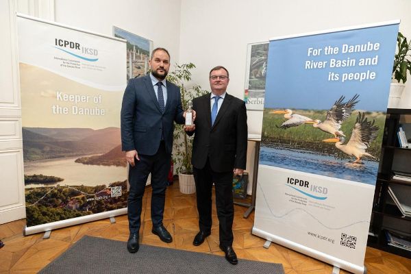 Der scheidende Präsident überreicht die symbolische Flasche Donauwasser an den neuen Präsidenten