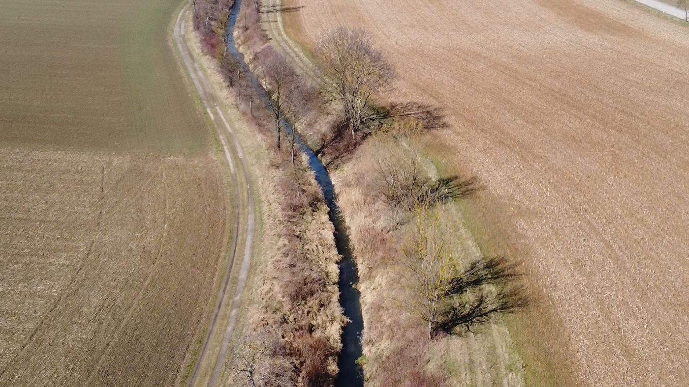 Das Bild zeigt einen kurzen Teilabschnitt des Verlaufes vom Göllersbach von oben, links und rechts sind Felder sichtbar