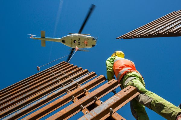 Das Aufstellen von Stahlschneebrücken mittels Helikopter und Wildbach- und Lawinenverbauarbeiter