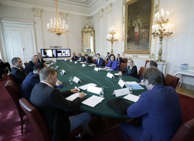 Mehrere Menschen bei einer Besprechung sitzend bei einem Tisch