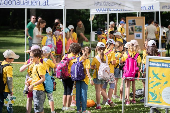 Kinder stehen in Gruppen vor Ständen des Nationalparks Donau-Auen bei der Danube Day-Veranstaltung 2022